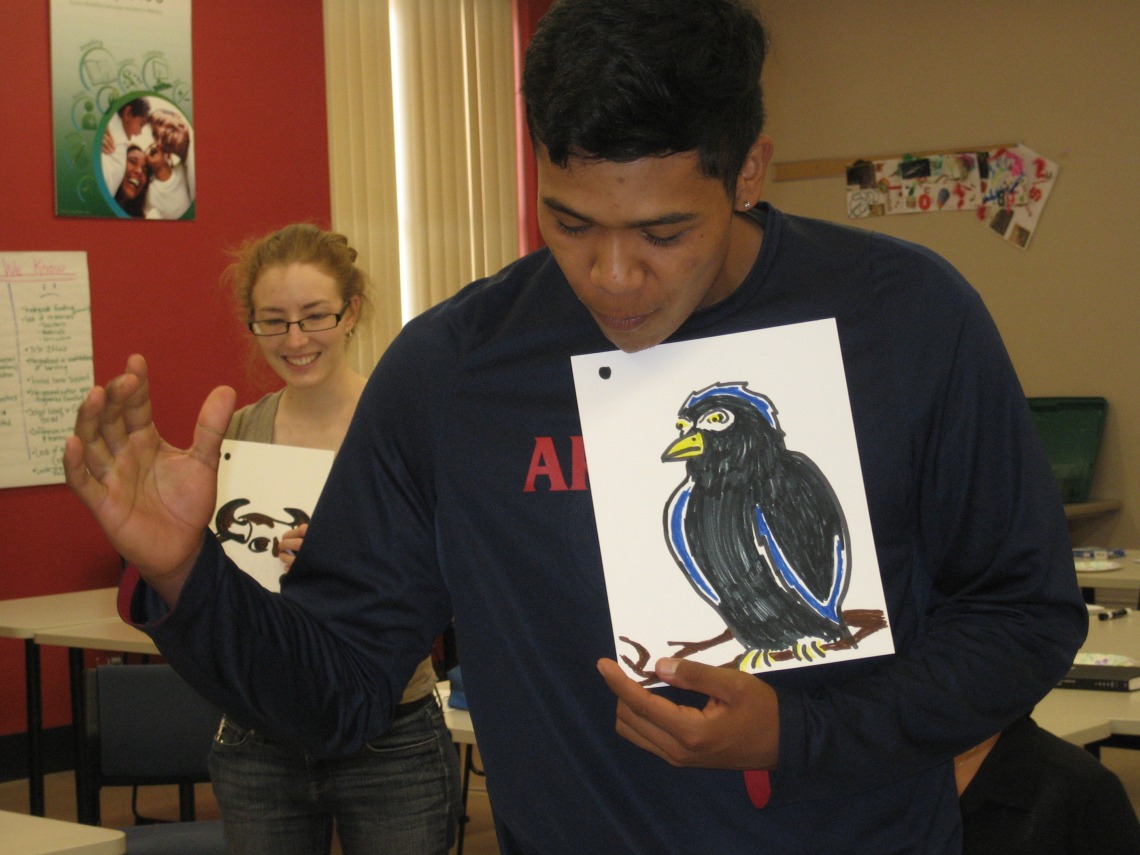 a male showing the drawing of a black bird