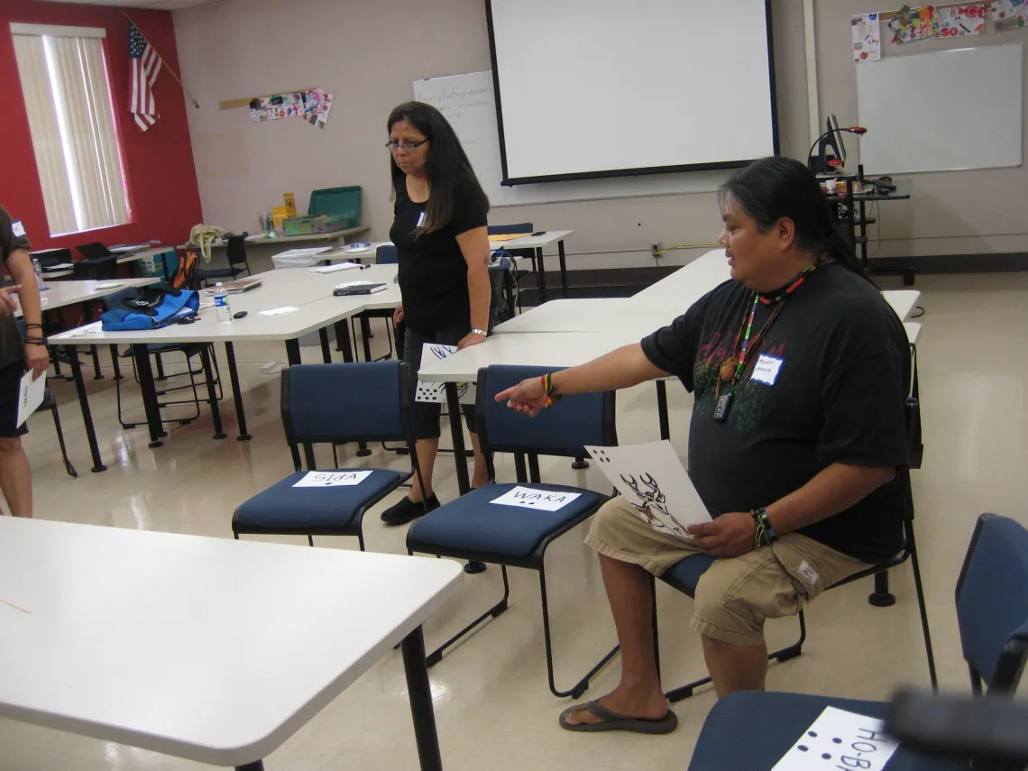 A male is pointing at a seat and a women is walking towards to it