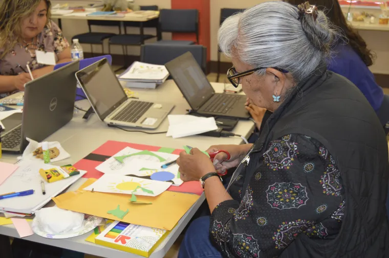 a lady with gray hair using scissors