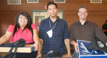 Two men and a woman smiling at the camera