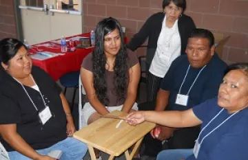 five people gathered around a table.